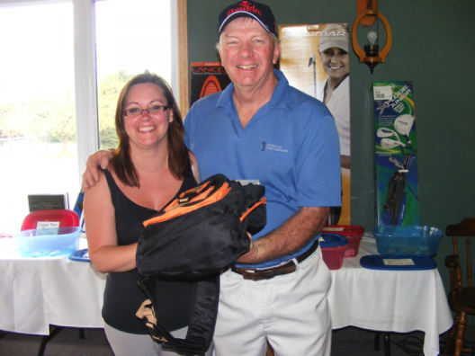 John Thompson of Waterloo, representing prize sponsor Sports & Scholarships, presents the ladies' longest drive prize to Angie Catalano of Cargill.
